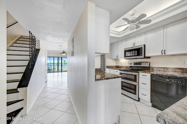 kitchen with a ceiling fan, a textured ceiling, appliances with stainless steel finishes, white cabinets, and light tile patterned floors