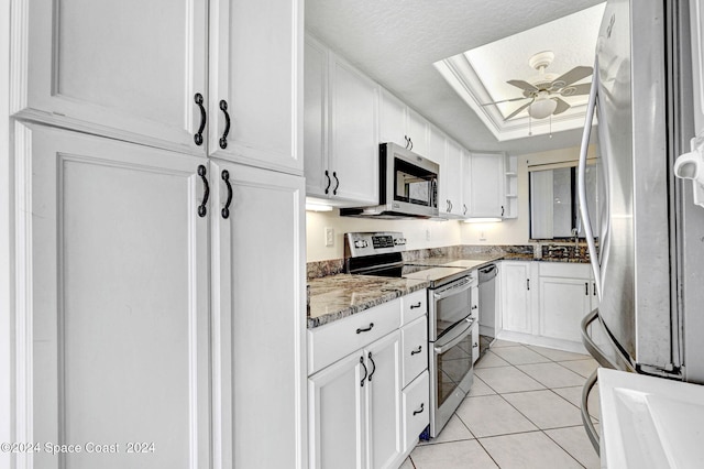 kitchen with ceiling fan, appliances with stainless steel finishes, white cabinets, stone countertops, and light tile patterned flooring