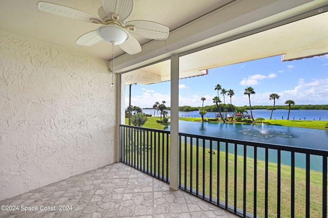 sunroom / solarium with a water view and ceiling fan