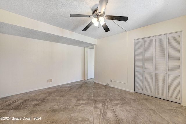 unfurnished bedroom featuring a textured ceiling, ceiling fan, and a closet