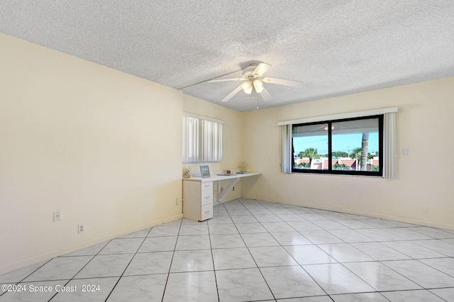 tiled empty room featuring a textured ceiling and ceiling fan