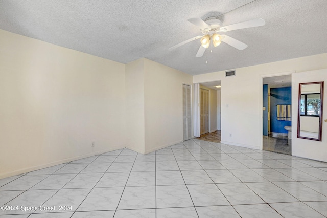 unfurnished room featuring baseboards, visible vents, a textured ceiling, and a ceiling fan