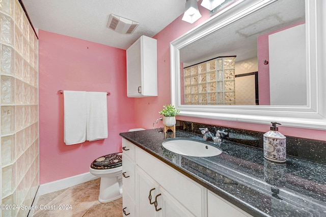 bathroom with vanity, tile patterned floors, a textured ceiling, and toilet