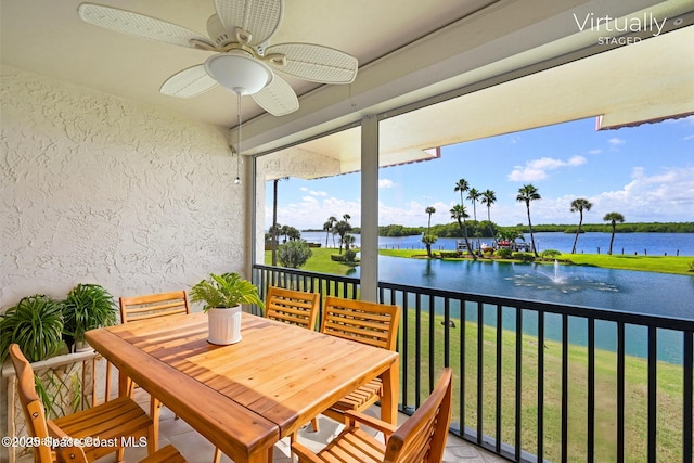 sunroom with a water view and ceiling fan