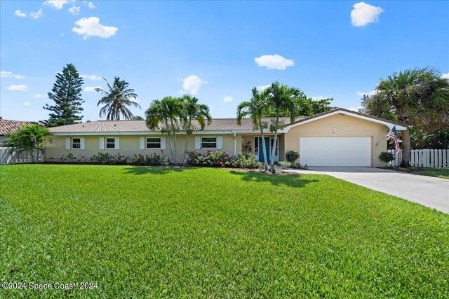 ranch-style home with a garage and a front lawn