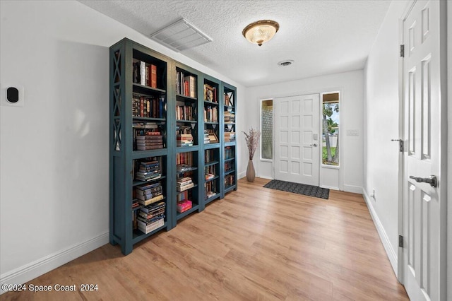 foyer entrance featuring hardwood / wood-style flooring and a textured ceiling