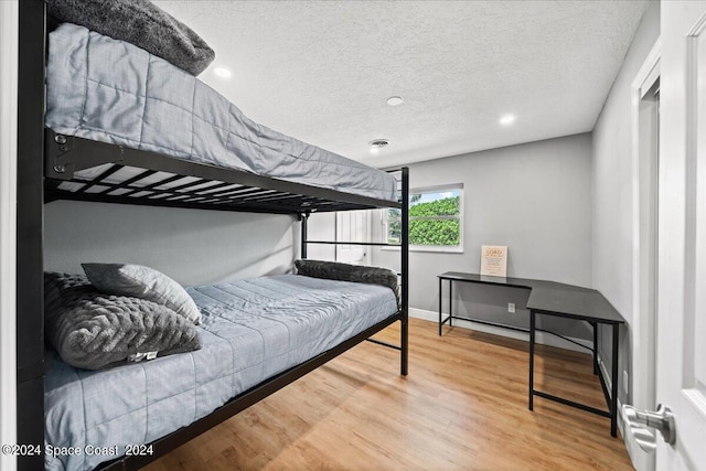 bedroom with hardwood / wood-style floors and a textured ceiling