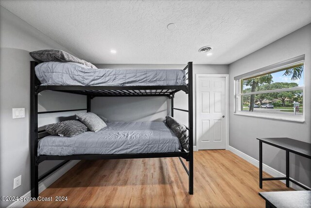 bedroom with hardwood / wood-style flooring and a textured ceiling