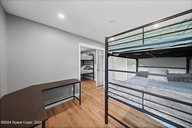 bedroom with light hardwood / wood-style flooring, a closet, and a textured ceiling