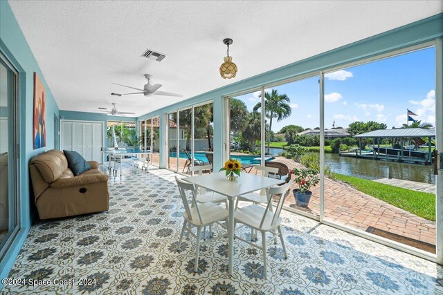 sunroom / solarium featuring a water view