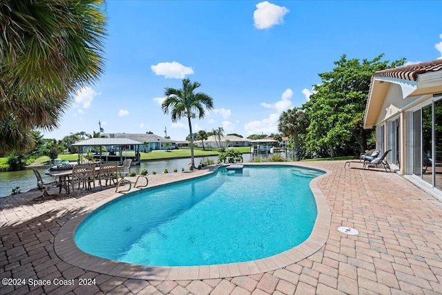 view of pool with a water view and a patio