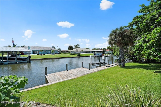 dock area with a water view and a lawn