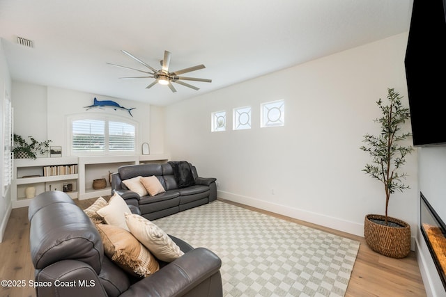 living room with ceiling fan and light hardwood / wood-style flooring