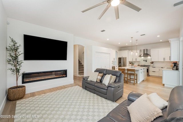 living room featuring ceiling fan and light wood-type flooring