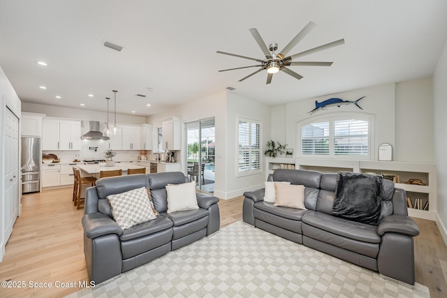 living room featuring ceiling fan and light hardwood / wood-style flooring