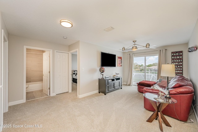 carpeted living room with ceiling fan