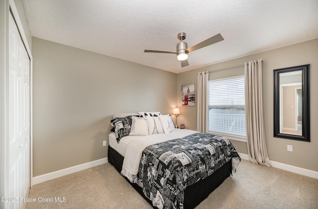 carpeted bedroom featuring ceiling fan, a closet, and a textured ceiling