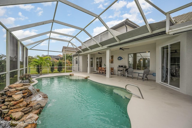 view of pool featuring pool water feature, ceiling fan, a patio, and glass enclosure