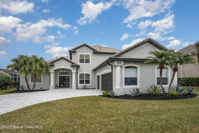 view of front of home with a garage, french doors, and a front lawn