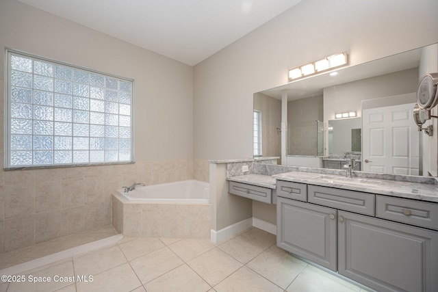 bathroom featuring vanity, tiled bath, and tile patterned flooring