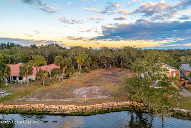 aerial view at dusk featuring a water view