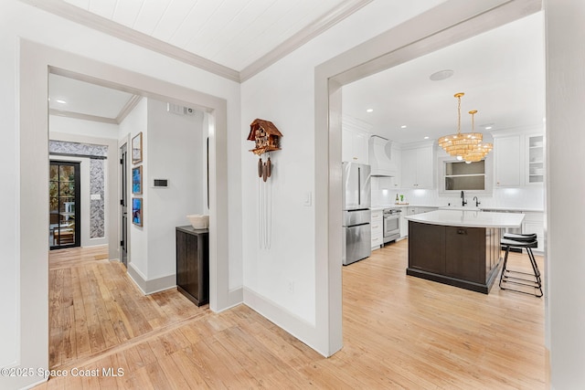 hallway featuring sink, light hardwood / wood-style flooring, and ornamental molding