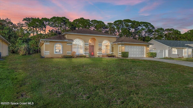 view of front facade with a garage and a lawn