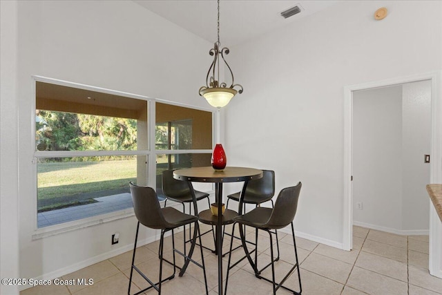 dining room featuring high vaulted ceiling and light tile patterned flooring