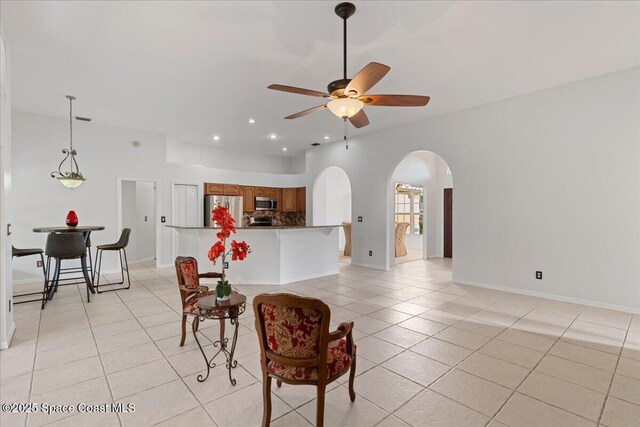 kitchen featuring light tile patterned flooring, appliances with stainless steel finishes, ceiling fan, and kitchen peninsula