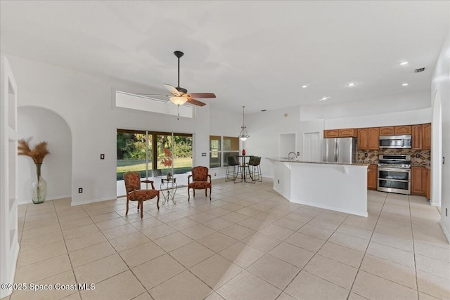 interior space featuring a high ceiling, sink, light tile patterned floors, and ceiling fan