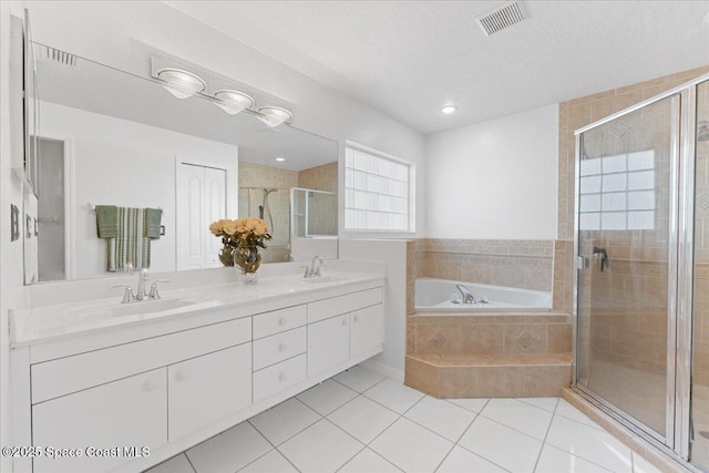 bathroom featuring vanity, independent shower and bath, tile patterned flooring, and a textured ceiling