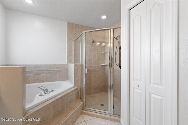 bathroom with tile patterned floors, independent shower and bath, and a textured ceiling