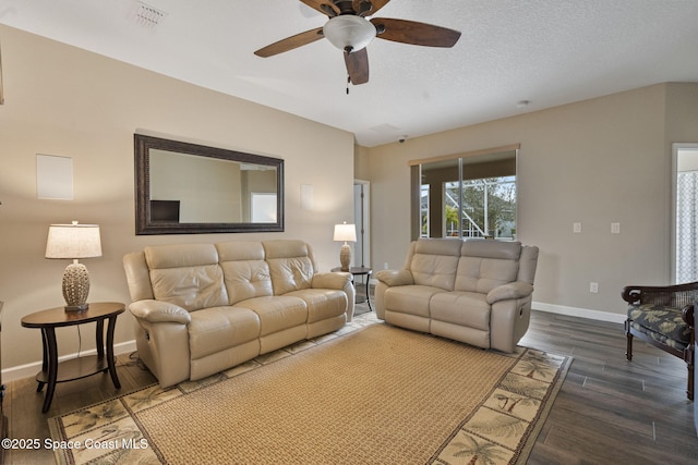 living room with ceiling fan, a textured ceiling, and dark hardwood / wood-style flooring