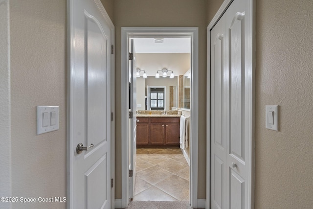 hall featuring light tile patterned floors