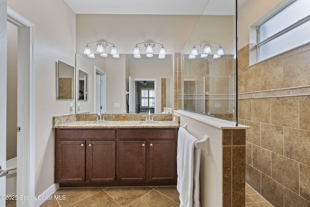 bathroom featuring tile patterned floors, tiled shower, and vanity