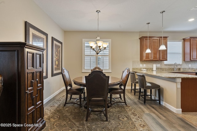 dining room featuring a healthy amount of sunlight, a chandelier, and dark hardwood / wood-style flooring