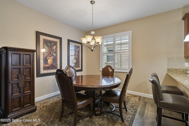 dining area with an inviting chandelier and dark wood-type flooring