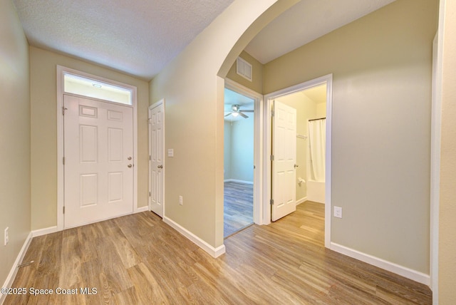 entrance foyer with light hardwood / wood-style floors and a textured ceiling