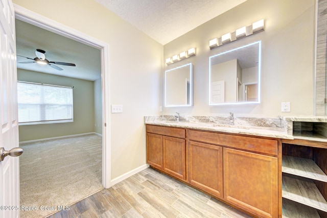 bathroom featuring vanity, ceiling fan, a textured ceiling, and wood-type flooring