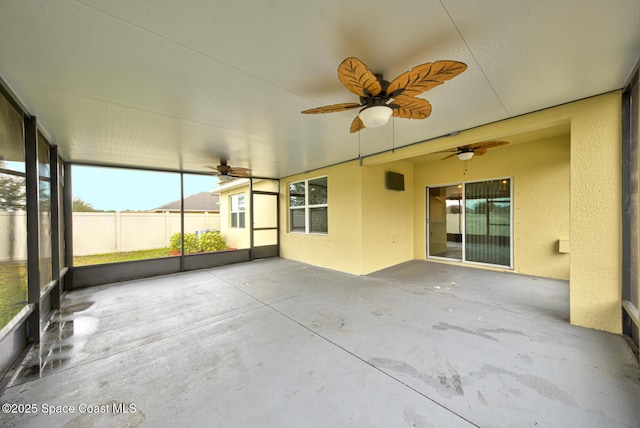 unfurnished sunroom featuring ceiling fan