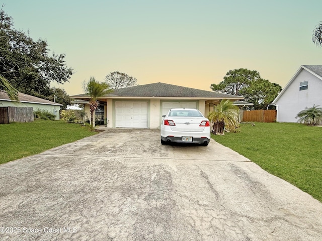 ranch-style house featuring a yard and a garage