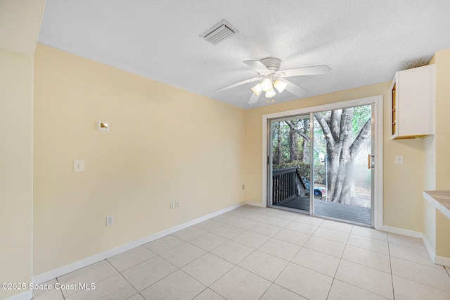 interior space with ceiling fan, a textured ceiling, and light tile patterned floors