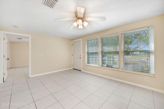 unfurnished room with a wealth of natural light, visible vents, and a textured ceiling