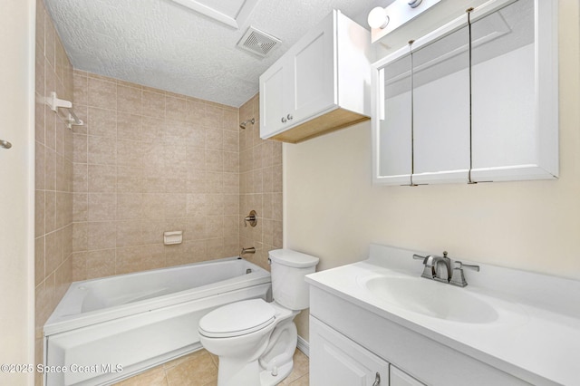 full bathroom featuring tile patterned flooring, vanity, a textured ceiling, tiled shower / bath, and toilet