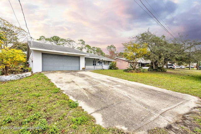 ranch-style home featuring a garage and a front lawn