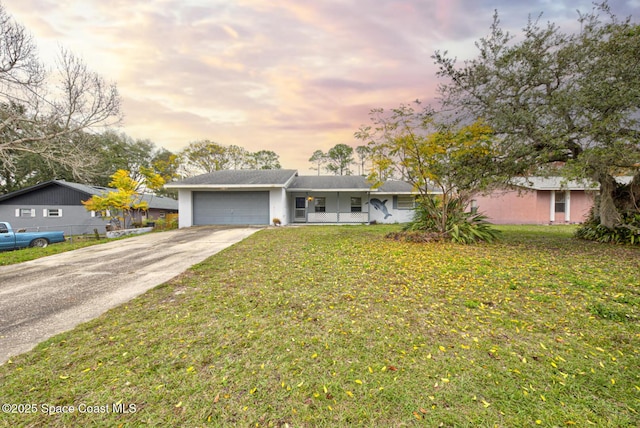 ranch-style home featuring a garage and a lawn