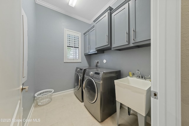 laundry room with crown molding, washing machine and clothes dryer, sink, and cabinets