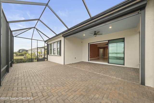 unfurnished sunroom featuring ceiling fan