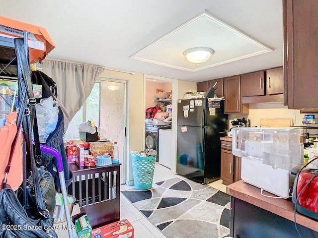 kitchen featuring black refrigerator and independent washer and dryer