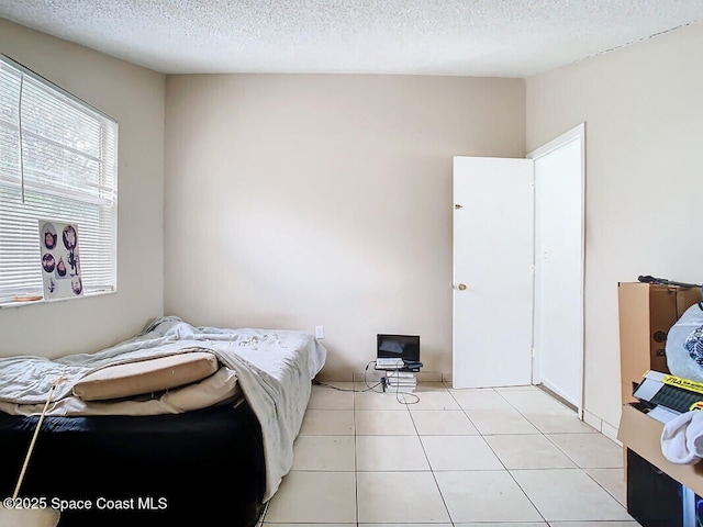 tiled bedroom with a textured ceiling